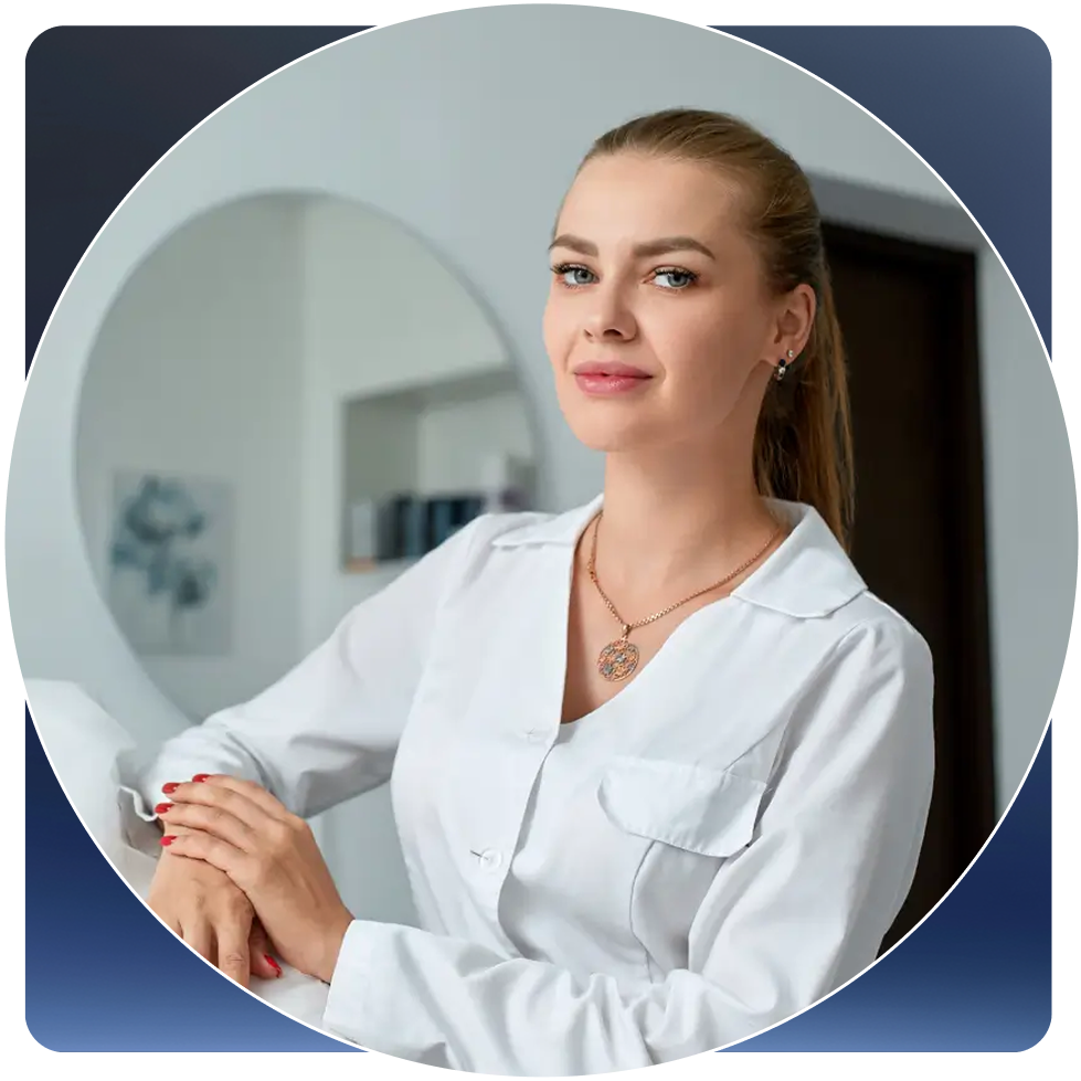 Woman in a white coat standing in a room with a mirror reflection.