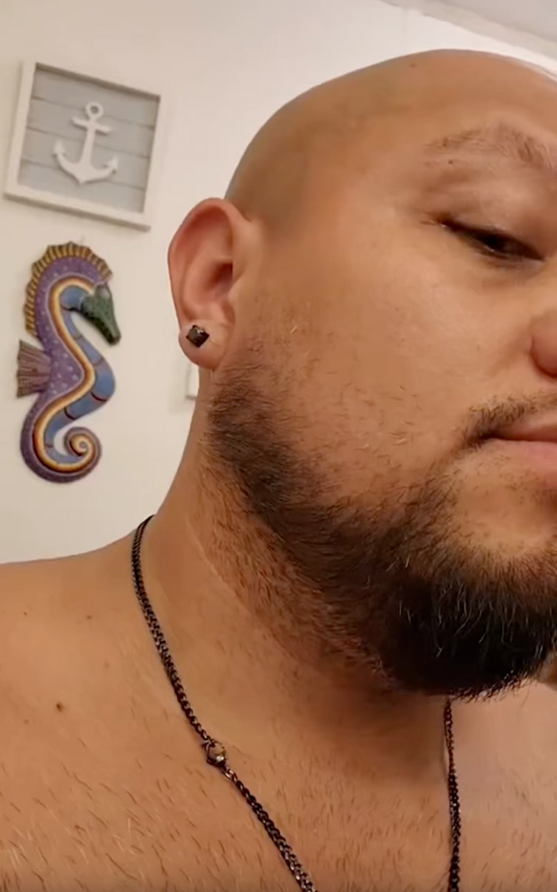 Close-up of a person wearing a black earring with a small object 

